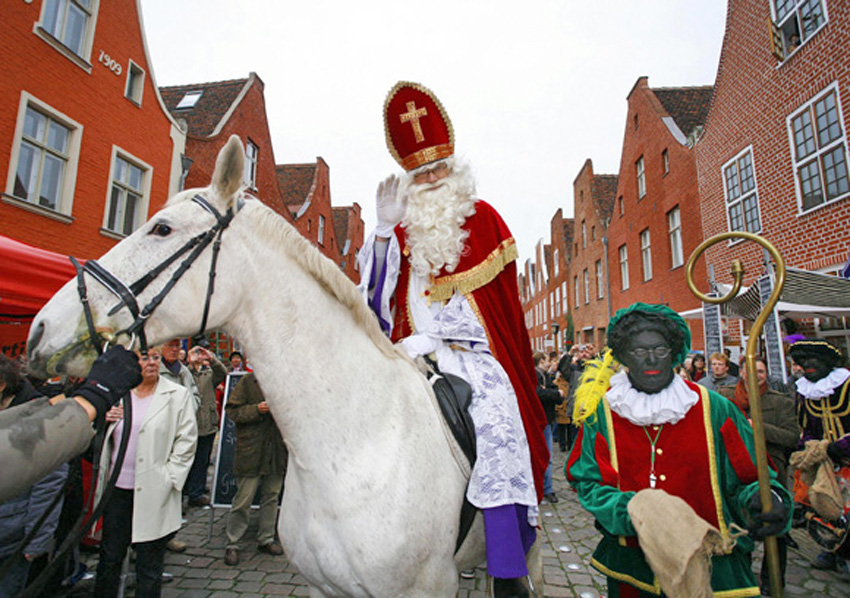 Sinterklaas (C) and his Zwarte Pieten (R