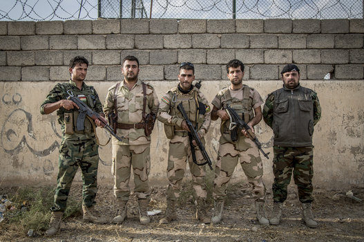 Peshmerga soldiers pose for a group portrait at a military base south of Erbil, the capital of the Kurdistan Regional Government in Iraq. (Vianney Le Caer/Pacific Press/LightRocket/Getty Images)