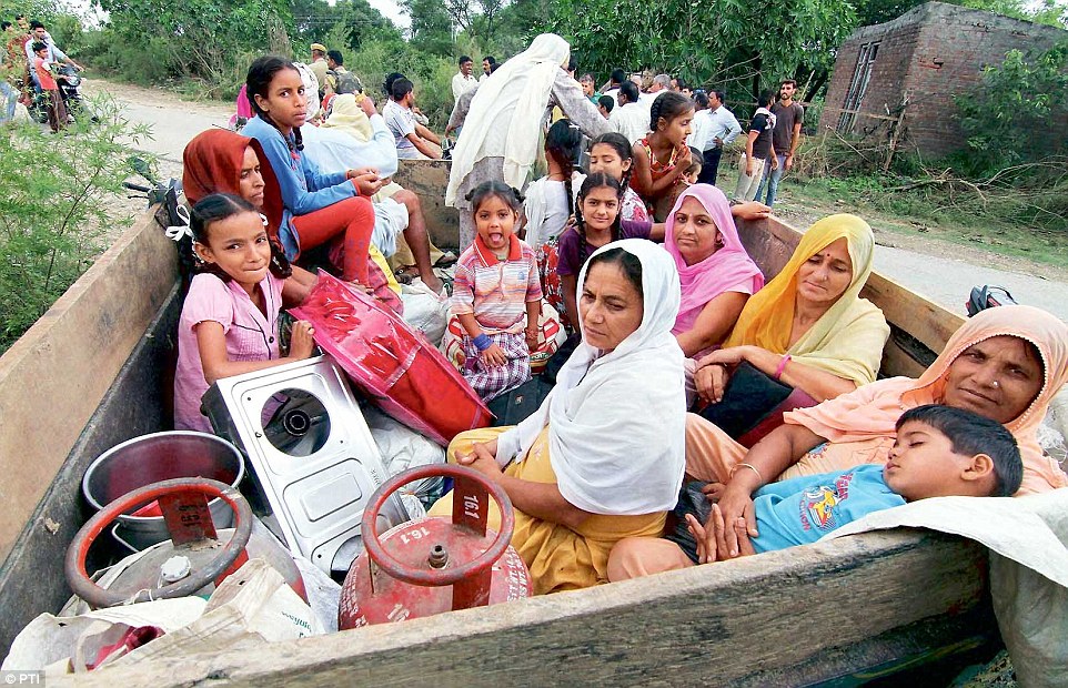 Residents of the Chilayari village in Samba district sit in a trailer as they prepare to leave the area following the death of two women who lived here. Read more: http://www.dailymail.co.uk/indiahome/indianews/article-2785698/Islamabad-shocked-Indian-Army-launches-massive-retaliation-border-firing-confident-PM-Modi-promises-right-soon.html#ixzz3FcbE8Tbr Follow us: @MailOnline on Twitter | DailyMail on Facebook