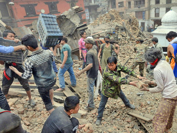 People clear rubble in Kathmandu's Durbar Square, a UNESCO World Heritage Site that was severely damaged by an earthquake on April 25, 2015. 