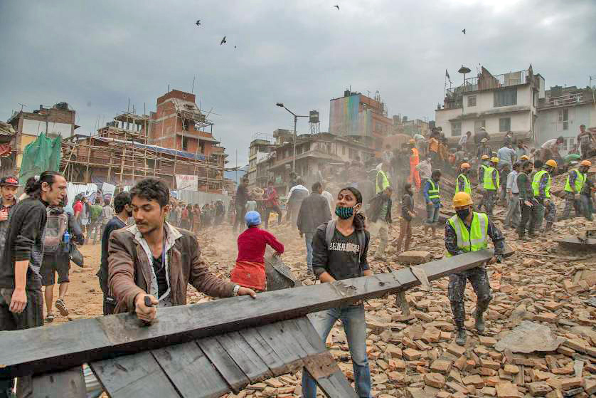 People clear debris in Basantapur Durbar Square while searching for survivors in Kathmandu.