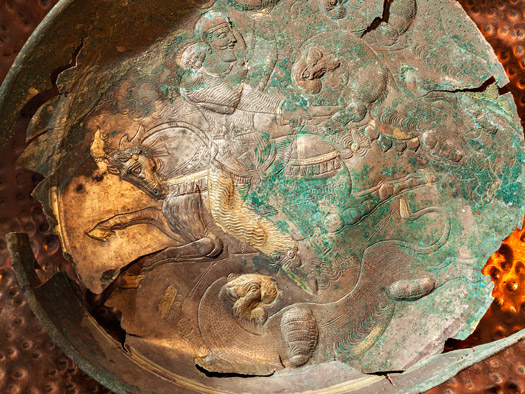 A detail of a copper and gold bowl from Tepe Baba Wali at Mes Aynak depicts a snarling lion. 