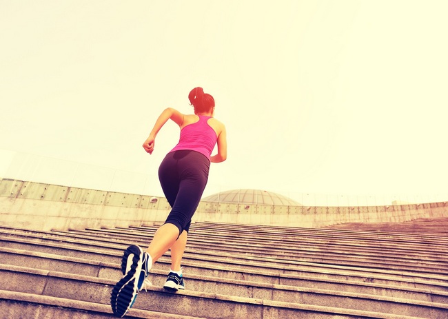 Runner athlete running on escalator stairs. woman fitness jogging workout wellness concept. ** Note: Visible grain at 100%, best at smaller sizes